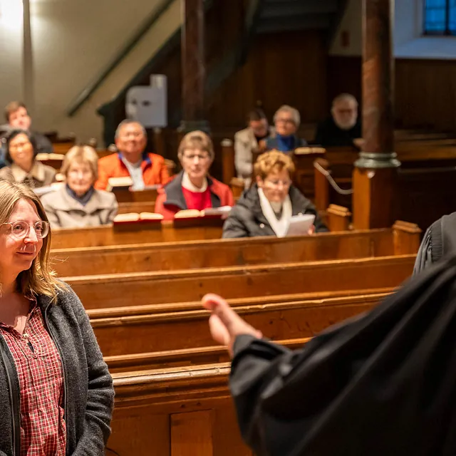 Ein Mann und eine Frau stehen vor der Gemeinde in einer Kirche.