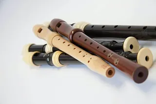 Eine Ansammlung von Blockflöten in verschiedenen Brauntönen.