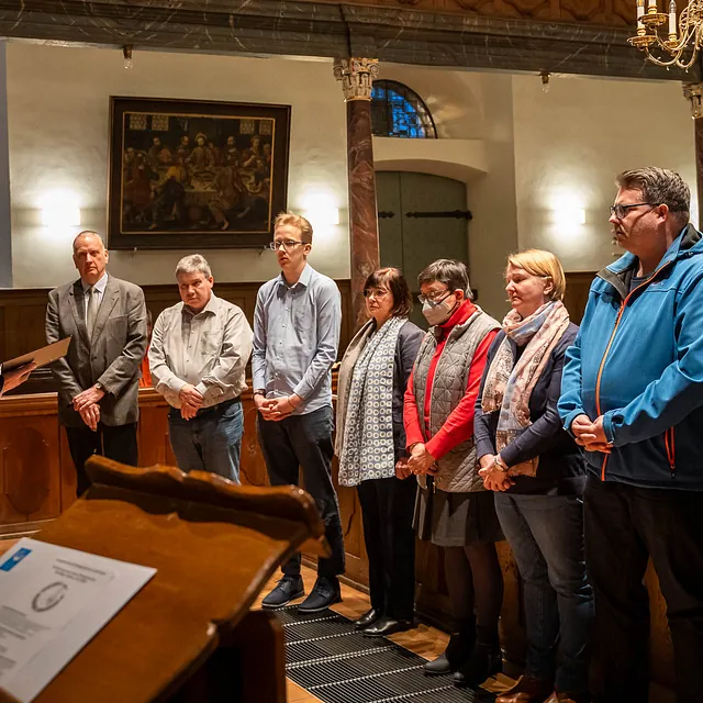 Gruppe von Personen steht in einer Reihe in einer Kirche.